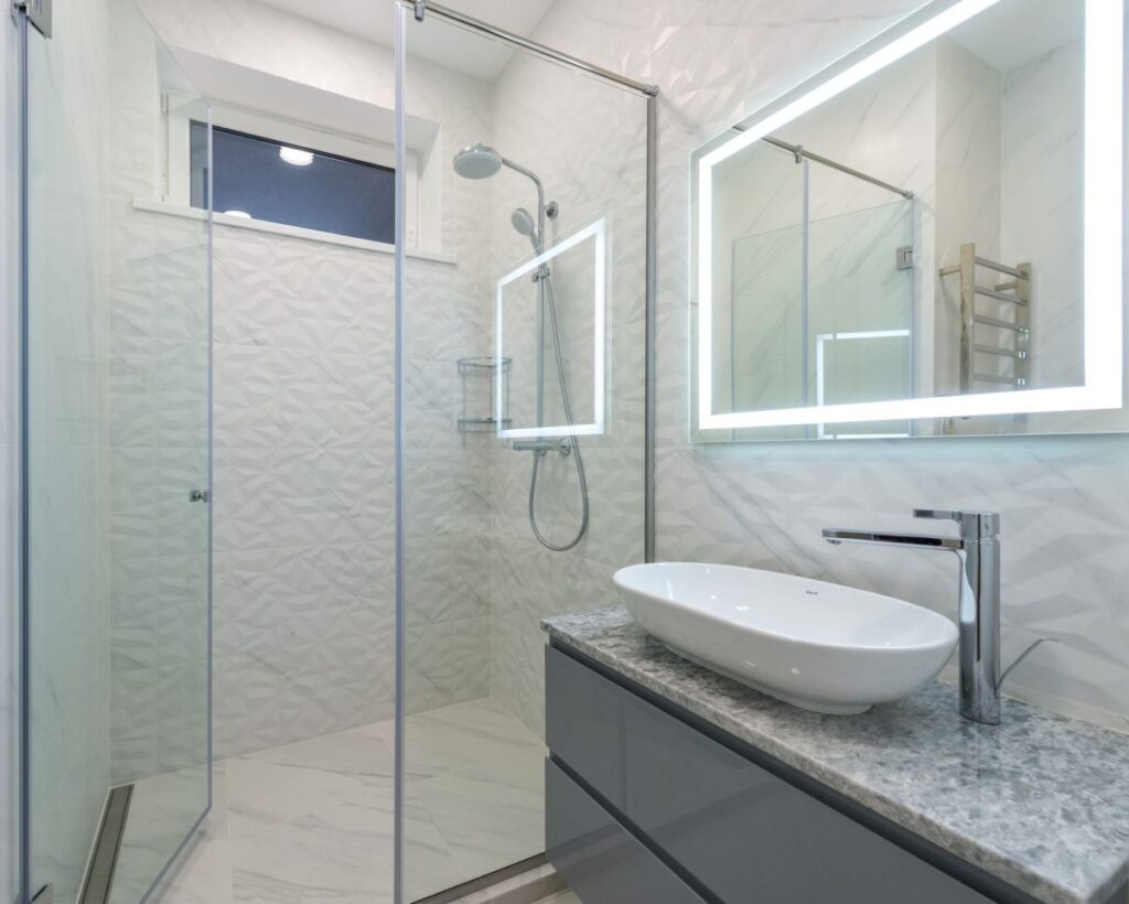Modern walk-in shower with large format tile and glass enclosure in Hurst TX home