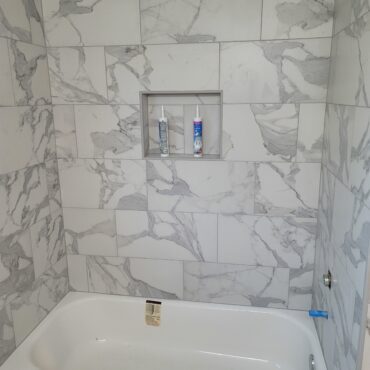 new tub install with large marble patterned tile