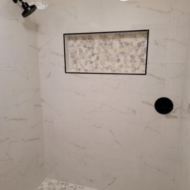 small stand up shower with insets and mosaic stone tile