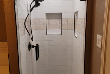 small stand up shower with insets and mosaic tile
