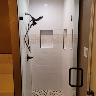 small stand up shower with insets and mosaic tile