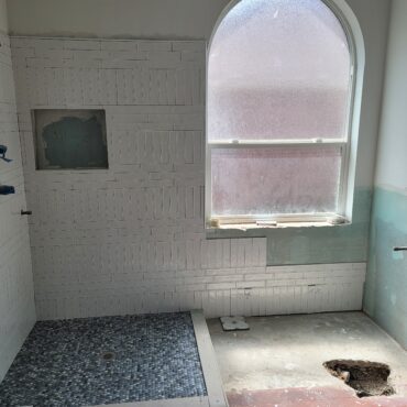 stand up shower being remodeled with arch window
