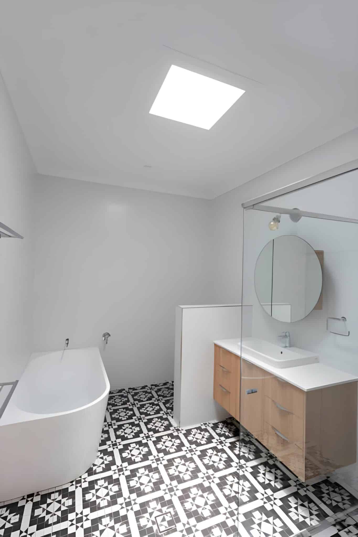 Contemporary bathroom design in South Arlington TX featuring matte black fixtures and wood-look porcelain tile.