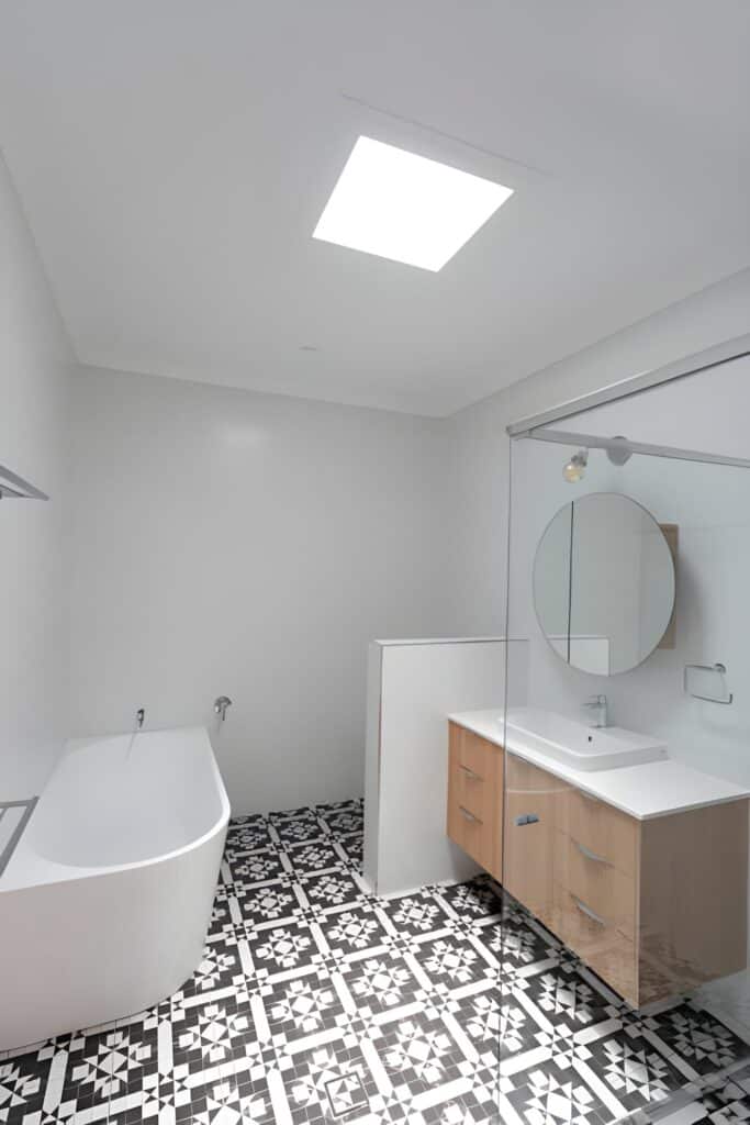 Contemporary bathroom design in South Arlington TX featuring matte black fixtures and wood-look porcelain tile.