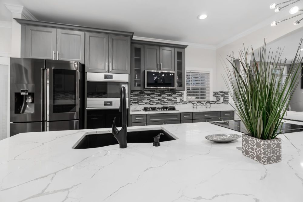 Installers placing quartz countertop slab in a newly remodeled Arlington kitchen