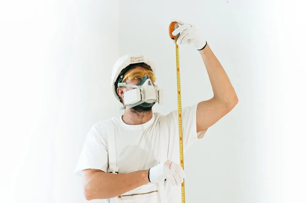 Remodeling contractor measuring bathroom shower space for accessibility upgrade