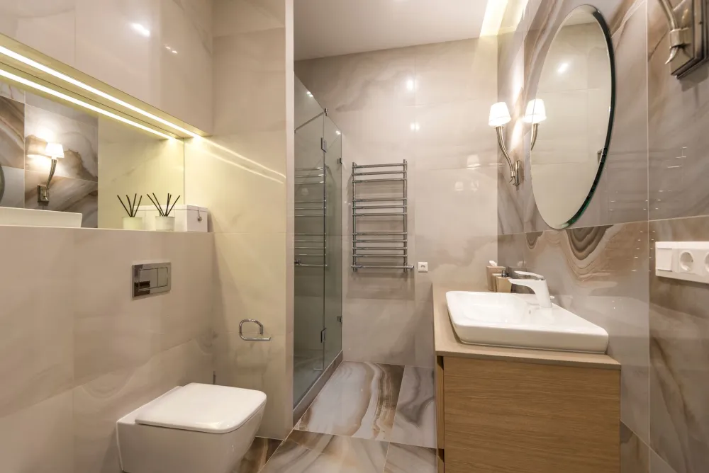 Finished modern bathroom with frameless glass shower and quartz countertop