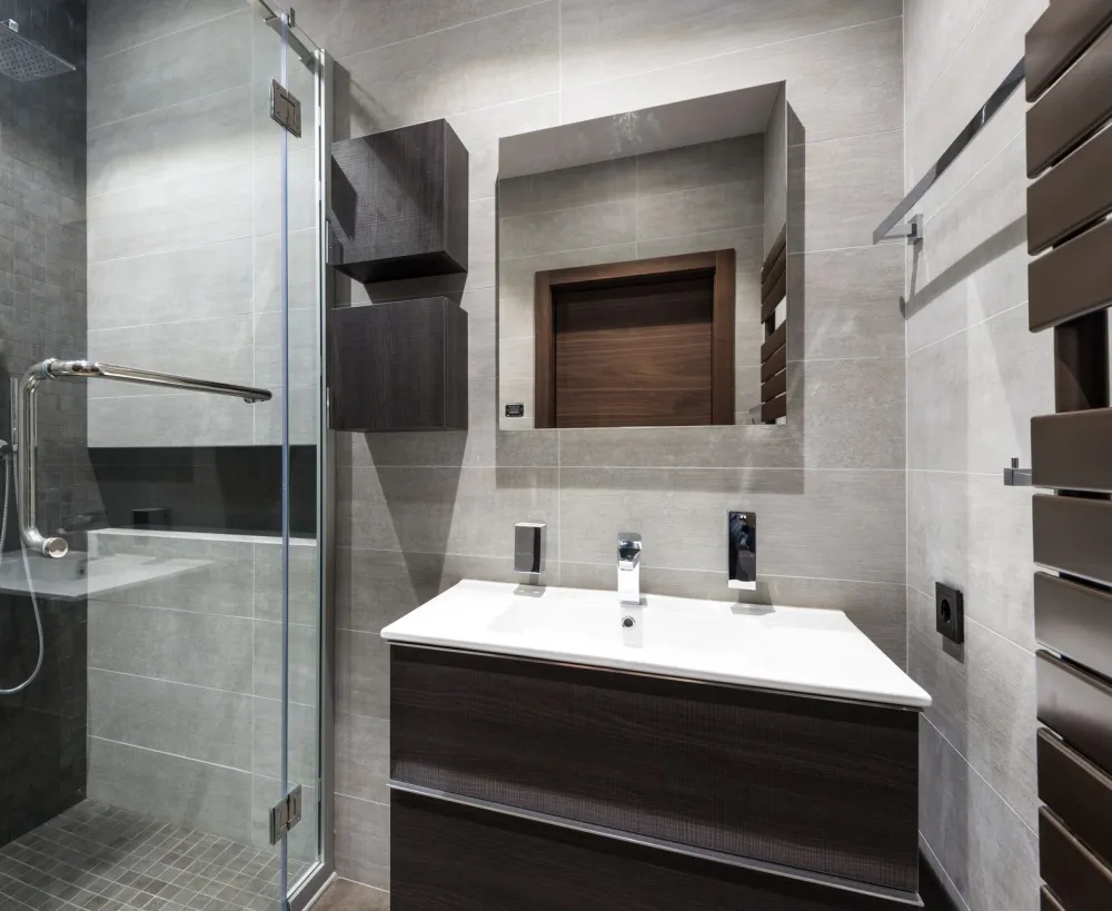 Bright finished bathroom renovation with frameless glass shower enclosure and new flooring