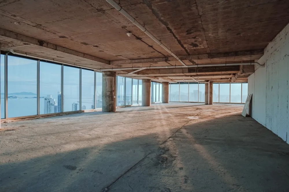 Open-plan office space under commercial finish-out construction showing framing and drywall