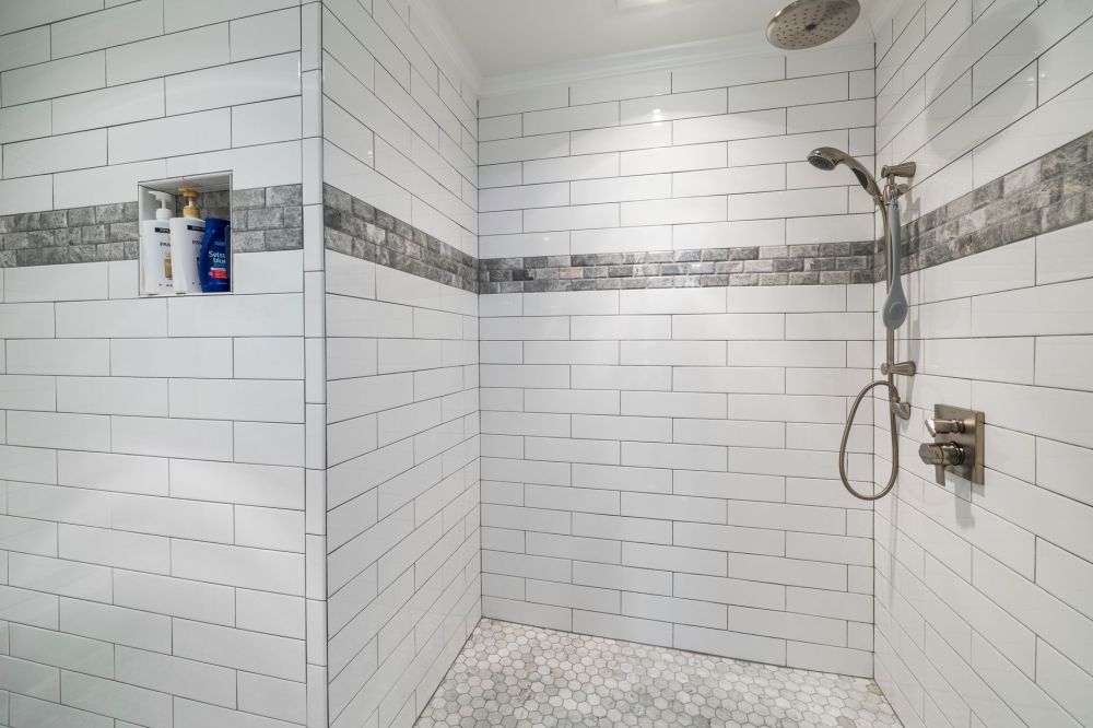 Large-format tile walls inside a walk-in shower during a bathroom renovation project