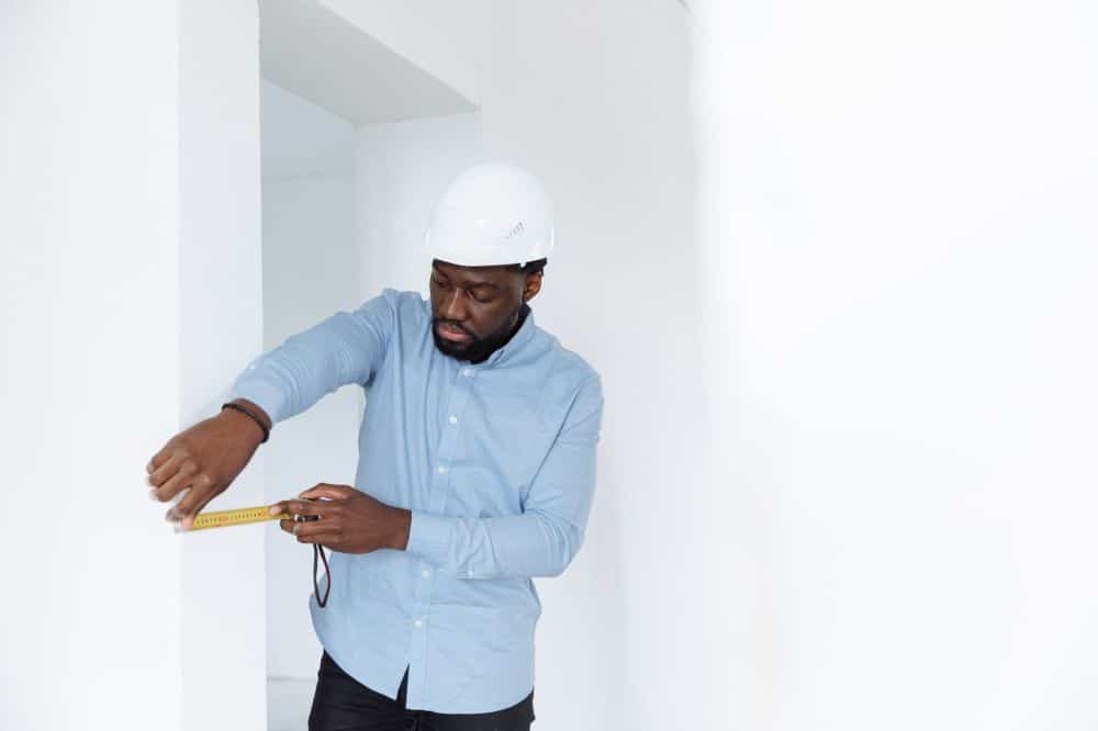 Remodeling contractor measuring shower area for frameless glass door installation
