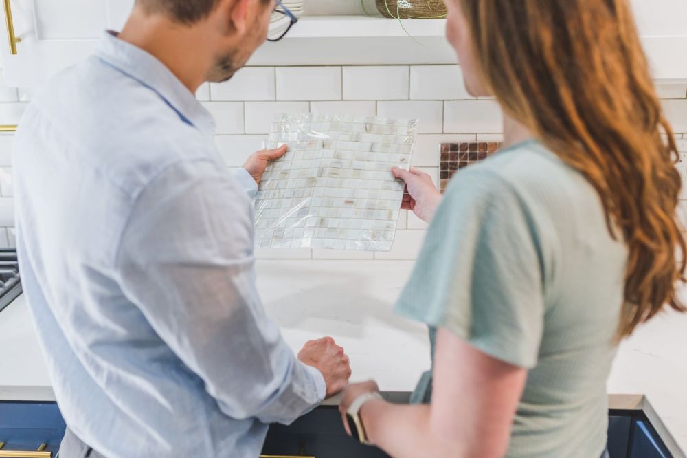 Homeowner and contractor reviewing kitchen remodel plans during an in-home estimate visit