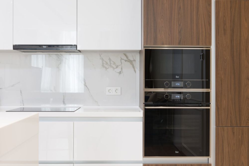 Side-by-side comparison of white and wood kitchen cabinets in a remodeled home