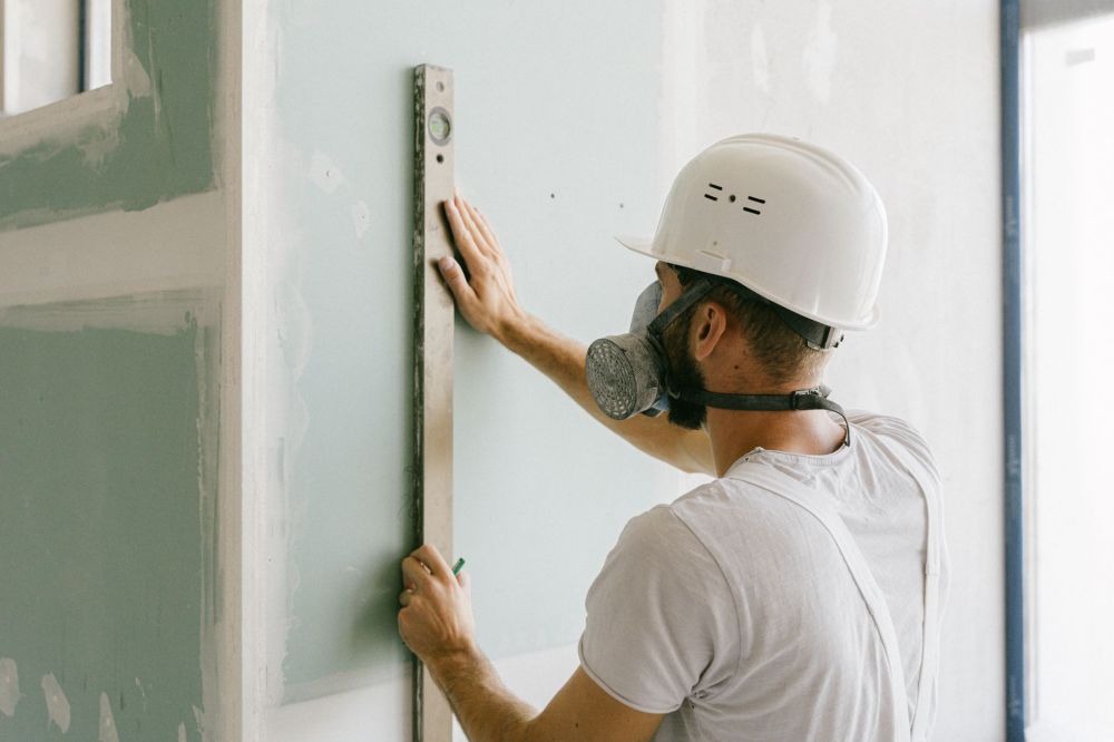 Licensed remodeling contractor measuring kitchen cabinets for a Bedford TX renovation estimate