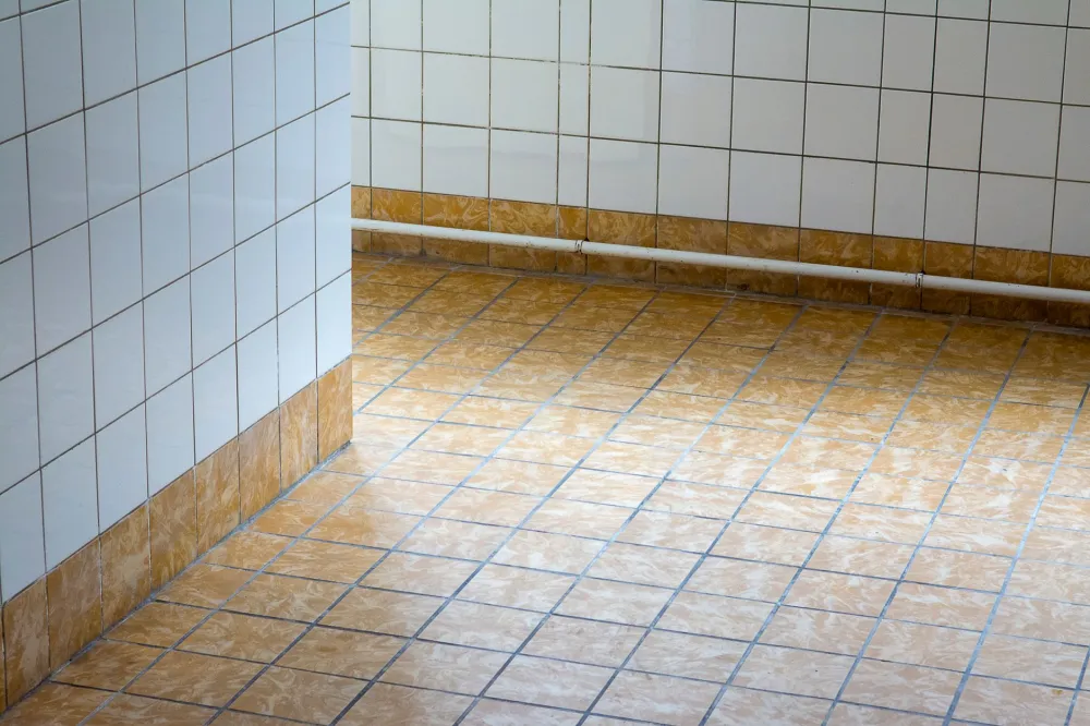 Contractor installing large-format tile flooring during a bathroom remodel in Arlington TX