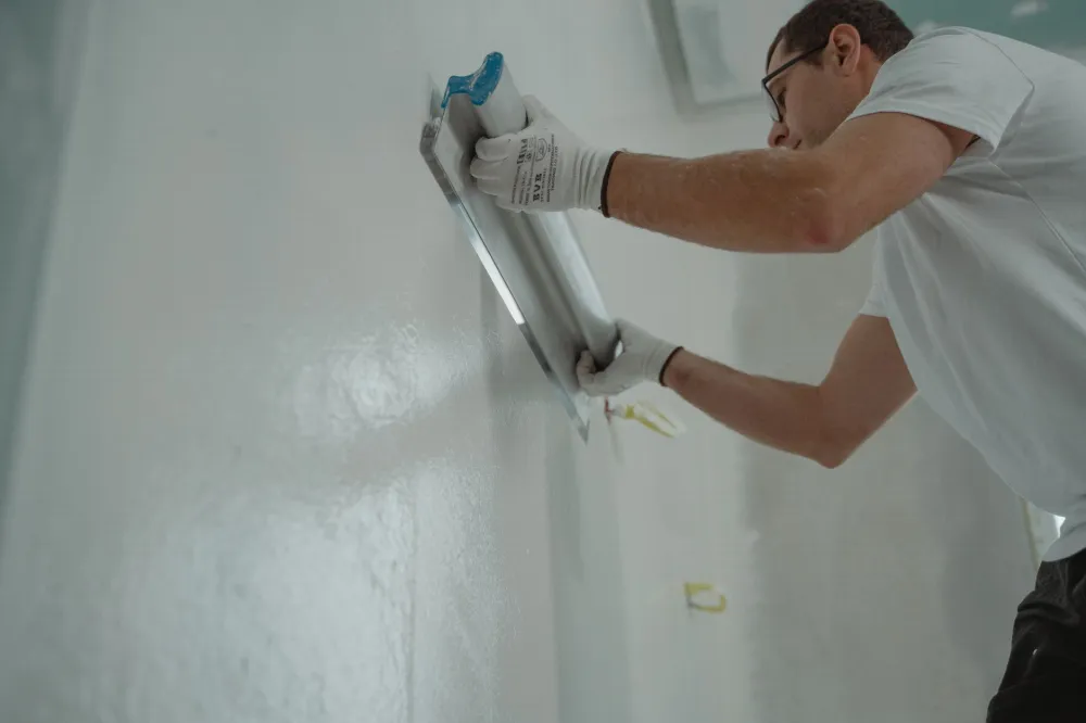 Professional painter rolling fresh neutral paint onto an Arlington home interior wall
