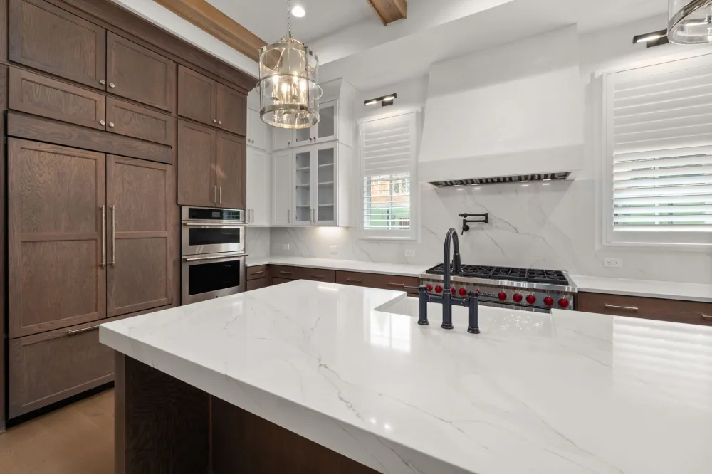 New quartz countertop kitchen island in a renovated DFW area home with modern lighting