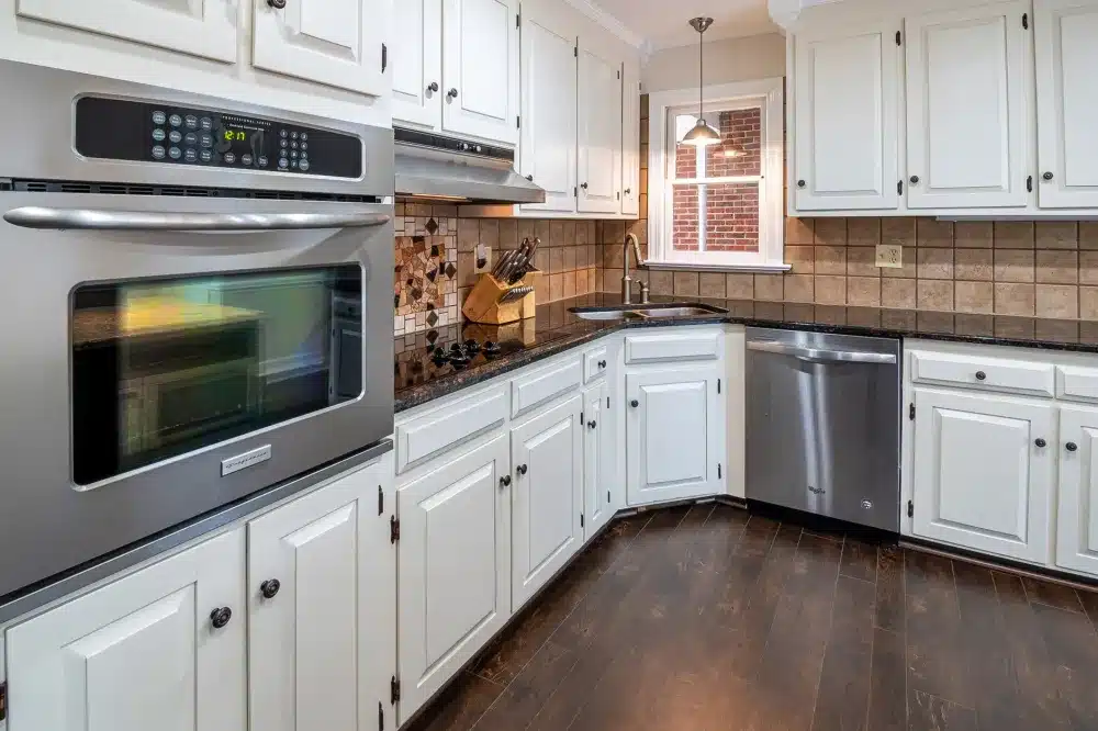 Kitchen cabinets being refinished and painted white during a budget-friendly remodel in DFW