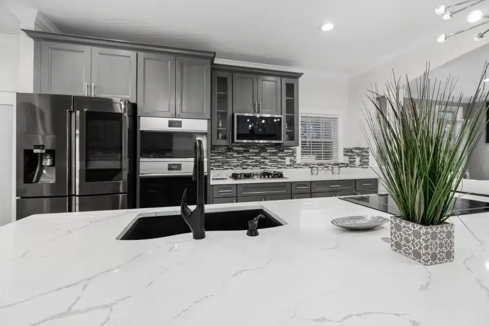 Contractor installing quartz countertop slab in a kitchen remodel project