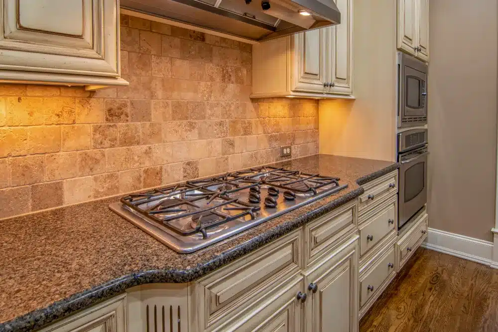 Tile backsplash being installed in a kitchen remodel alongside new cabinets and countertops