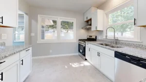 Newly remodeled kitchen with white shaker cabinets and quartz countertops in Hurst TX home