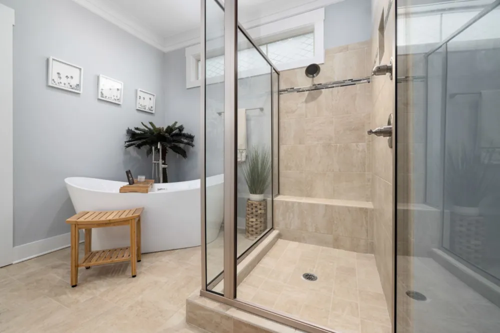 Frameless glass shower enclosure with large format tile in a master bathroom remodel