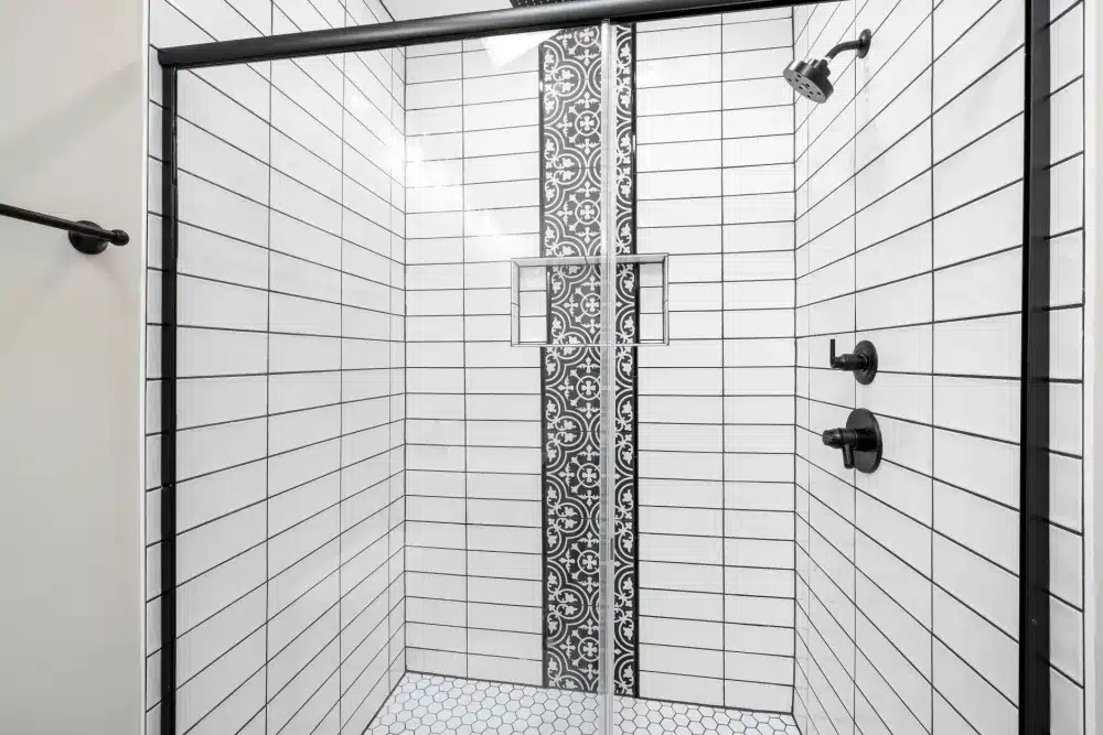 Classic subway tile shower surround with contrasting grout in a remodeled bathroom