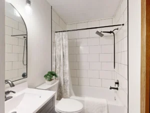 Modern shower remodel with large-format tile and frameless glass enclosure in Arlington TX home