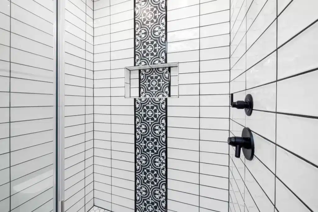 Modern walk-in shower with large format tile and frameless glass door in Arlington TX home