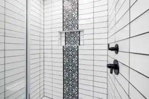 Modern walk-in shower with large format tile and frameless glass door in Arlington TX home