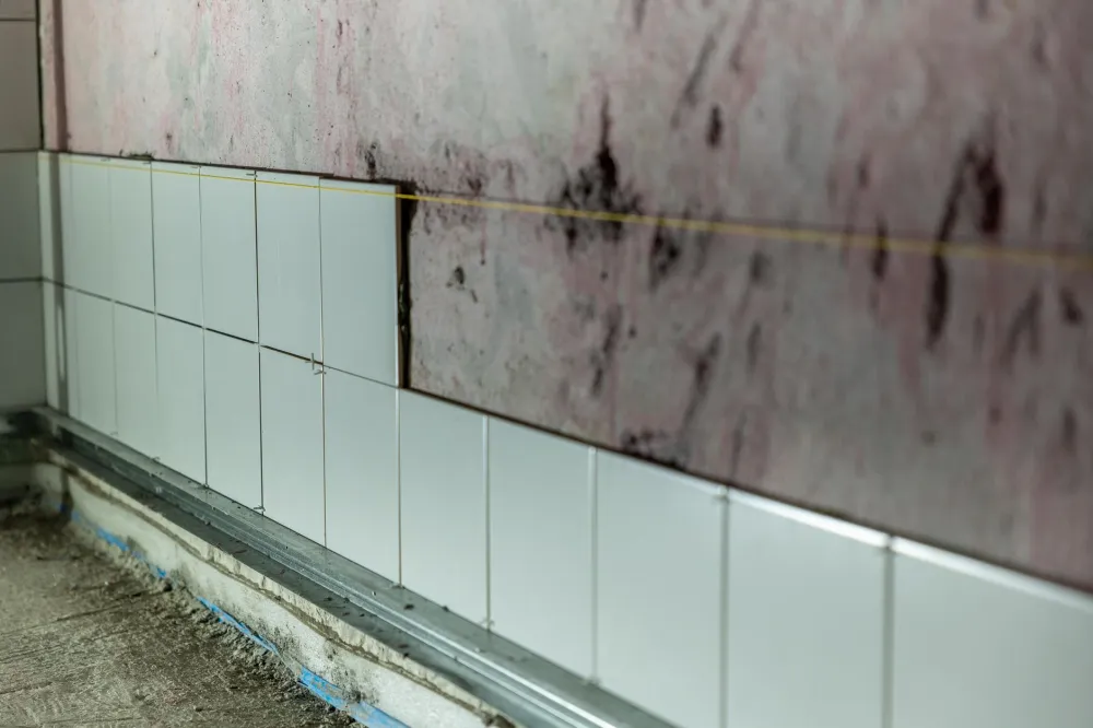 Contractor applying waterproofing membrane before shower tile installation in Arlington TX