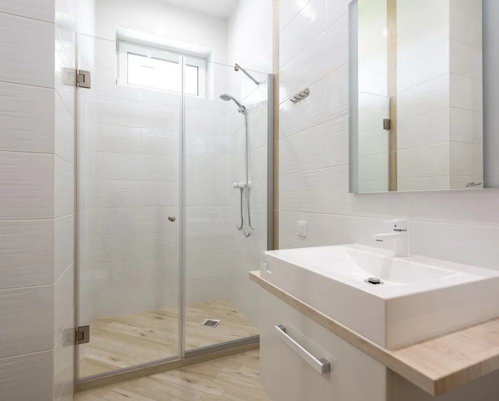 Frameless glass walk-in shower enclosure in a renovated Arlington Texas bathroom