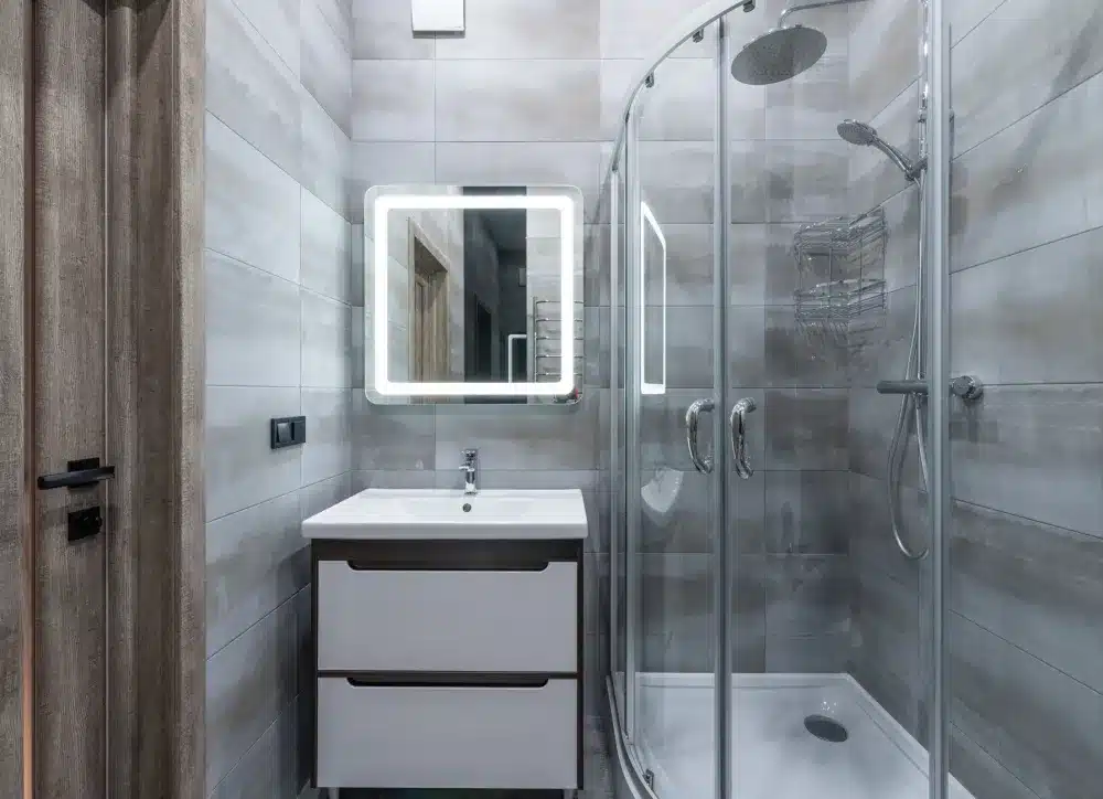 Contractor applying waterproofing membrane during walk-in shower installation in a DFW home