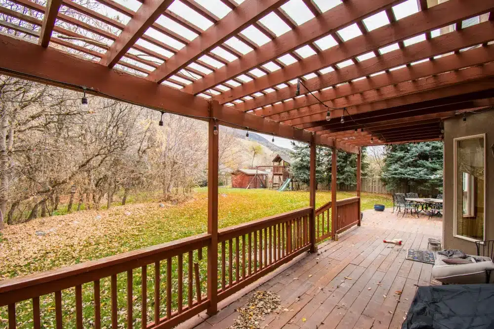 Attached wood pergola with lattice roof over a concrete patio in a DFW suburban backyard