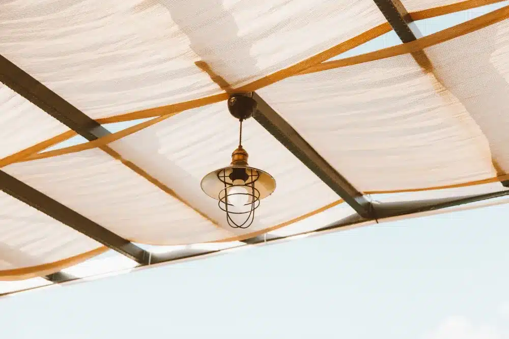 Insulated aluminum patio cover with ceiling fan installed on a Texas home in summer