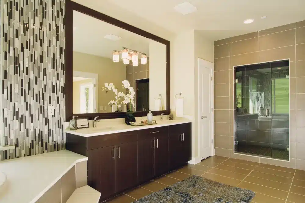 Tile installer setting large format shower tiles during bathroom renovation rough-in phase