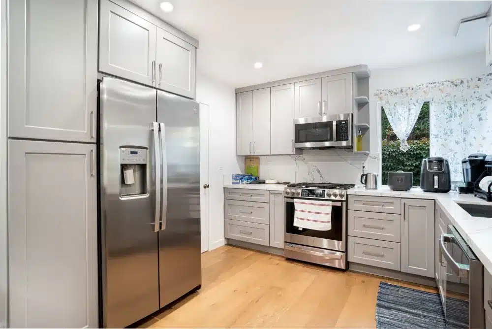 Contractor installing white shaker kitchen cabinets during a Texas home remodel