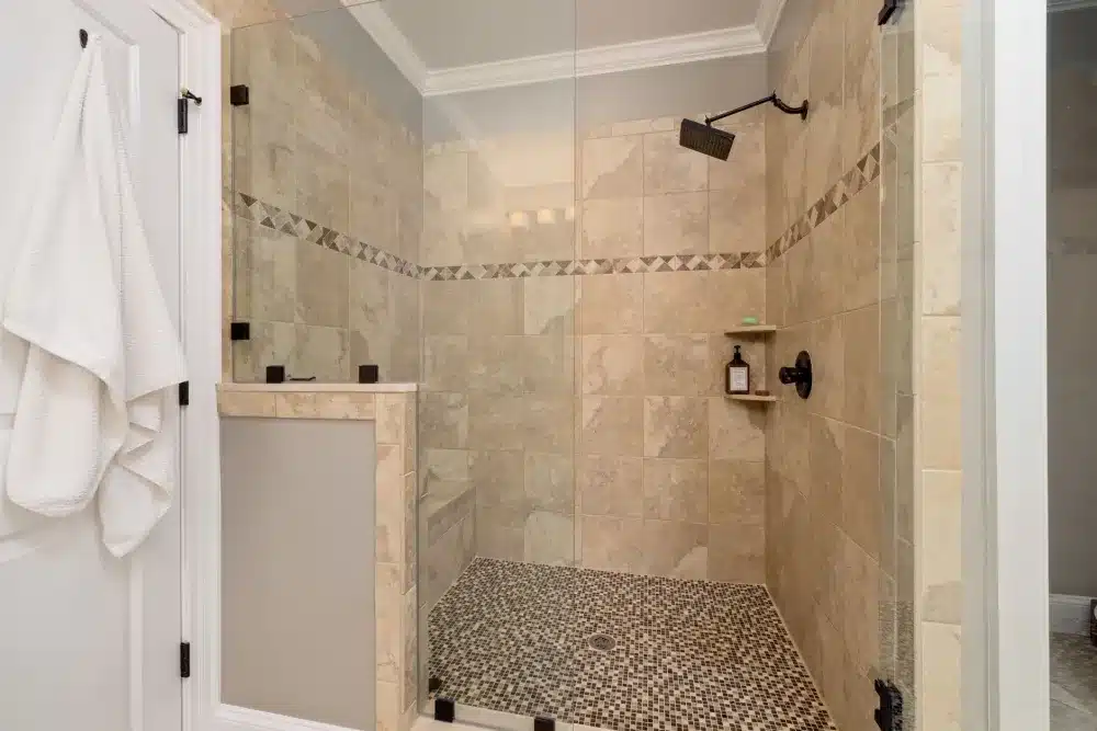 Large walk-in shower with frameless glass enclosure and floor-to-ceiling tile in master bath