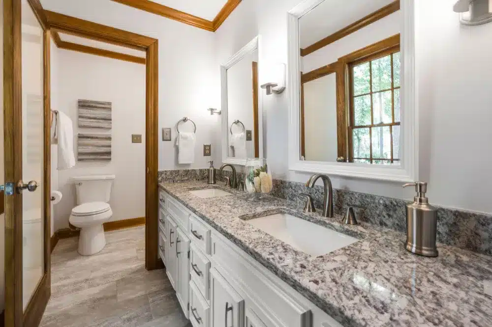 Double vanity with quartz countertop and under-cabinet lighting in a remodeled master bathroom