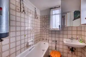 Outdated Arlington TX bathroom showing worn fixtures and signs you need to remodel your bathroom