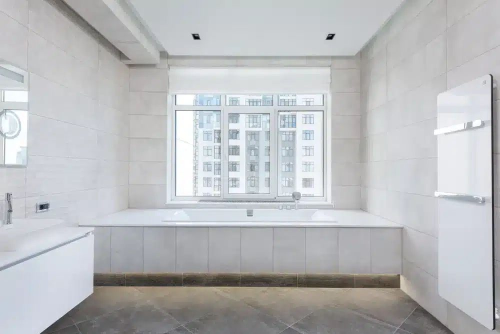 Large-format floor tile with minimal grout lines in a small bathroom renovation
