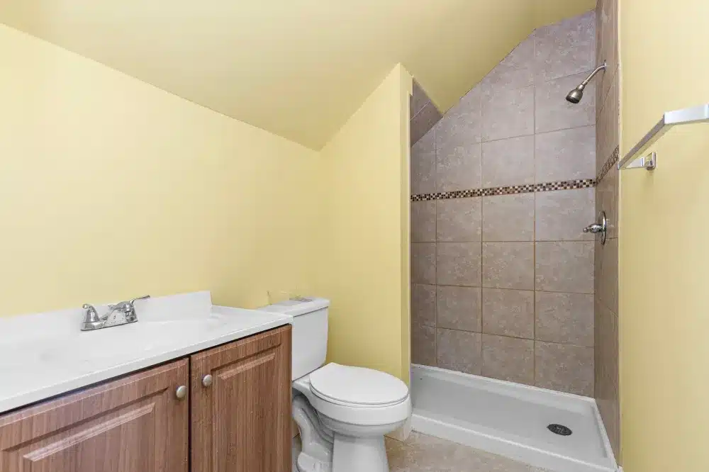 Walk-in shower with subway tile walls and frameless glass door in a DFW home