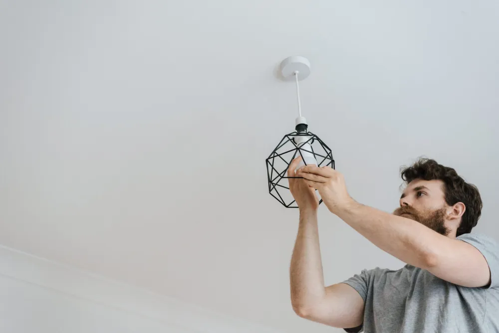 Electrician installing airtight recessed LED cans in a Fort Worth kitchen ceiling