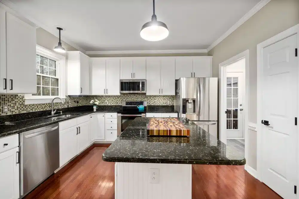 Finished Fort Worth kitchen with pendants over the island and dimmed ambient light