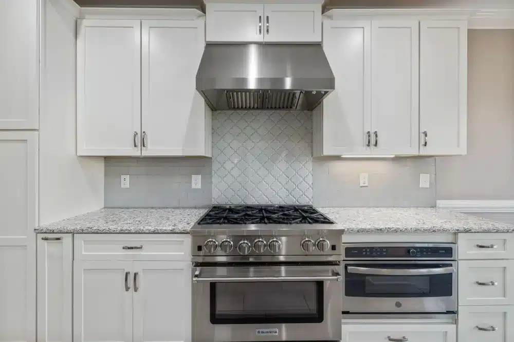Wall-mounted chimney hood above a range in a remodeled kitchen