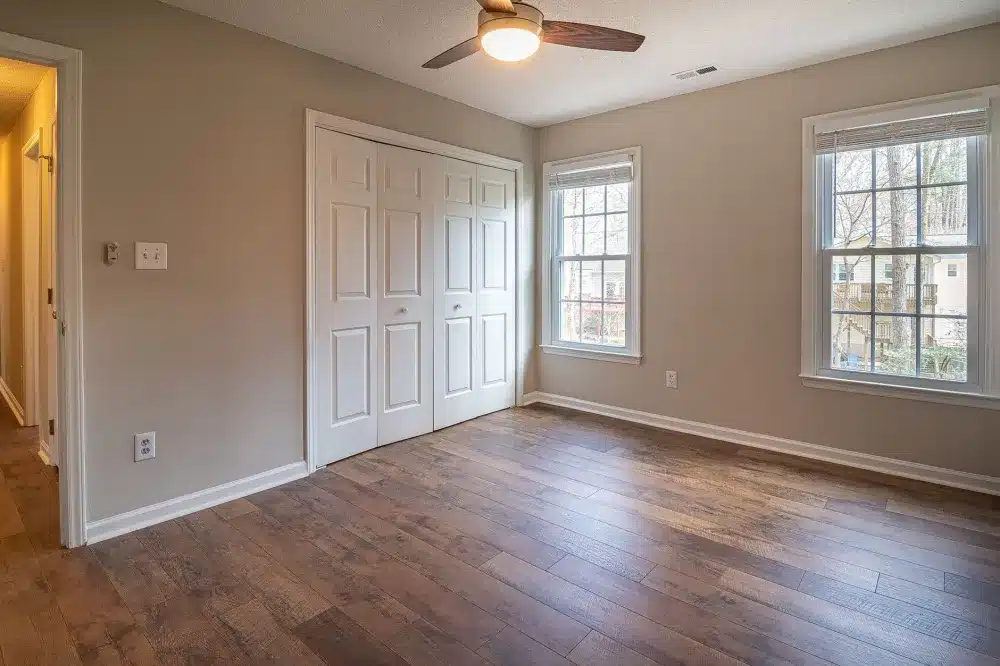 Contractor installing luxury vinyl plank flooring in a rental property remodel