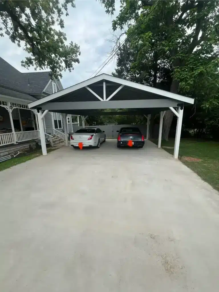 Two-car carport with white posts and gray beams over the driveway of a Weatherford, TX home